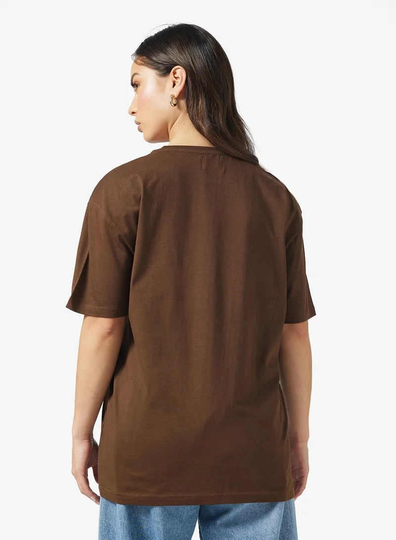 جينجر تيشيرت بياقة دائرية وشعار